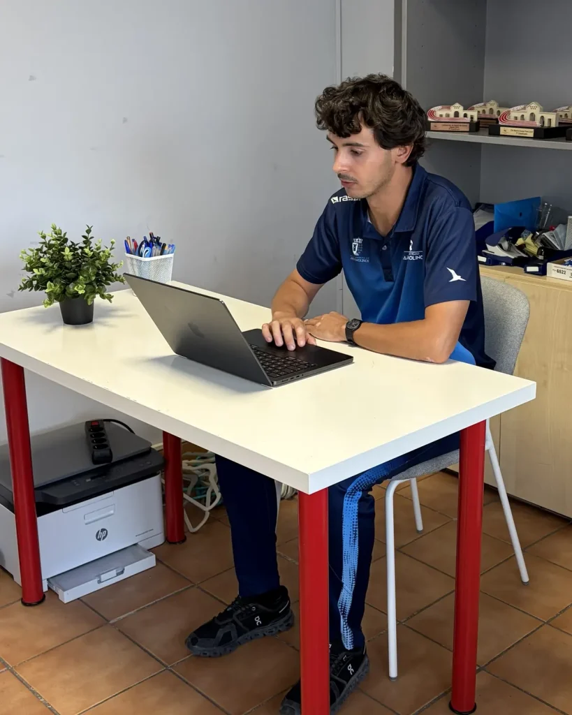 Daniel Gomez trabajando con el portatil en la oficina del club